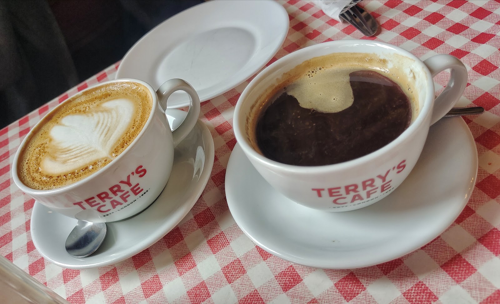 Two Terry's Cafe coffees on the red gingham cloth